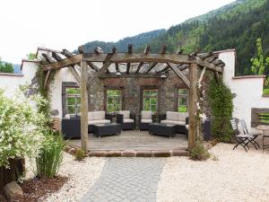 a pergola with couches and chairs on a patio at Landgasthaus Grüner Baum in Simonswald