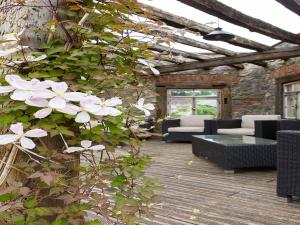 a patio with black chairs and white flowers at Landgasthaus Grüner Baum in Simonswald