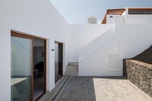 een wit huis met een trap en glazen deuren bij Villas Altos de Lanzarote in Playa Blanca