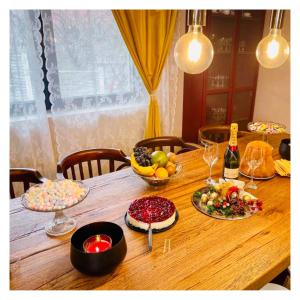 una mesa de madera con cuencos de frutas y botellas de vino en Vila Montana Valiug, en Văliug