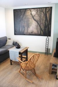 sala de estar con silla y sofá en Isäntä en La Ferté-Saint-Aubin