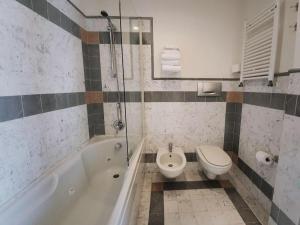y baño con bañera, aseo y lavamanos. en Hotel Bracciotti en Lido di Camaiore