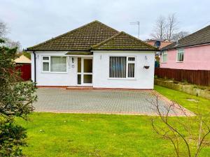 una casa blanca con una valla y un patio en Cherry Tree Lodge, en Norwich