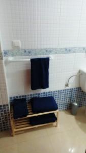 La salle de bains est pourvue de 2 serviettes bleues sur un mur. dans l'établissement Apartamento Rural Forest Home, à El Bosque
