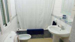 La salle de bains blanche est pourvue d'un lavabo et de toilettes. dans l'établissement Apartamento Rural Forest Home, à El Bosque