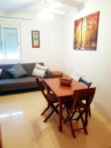 - un salon avec une table, des chaises et un canapé dans l'établissement Apartamento Rural Forest Home, à El Bosque
