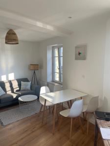 sala de estar con mesa y sofá en Lamballe plein centre, superbe appartement 1er étage, en Lamballe