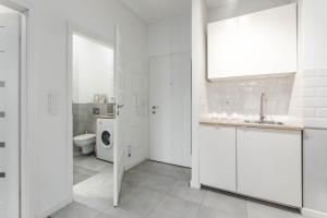 a white bathroom with a white toilet and sink at Chill Apartments Airport Apartments in Warsaw