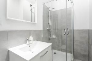 a bathroom with a shower, sink, and toilet at Chill Apartments Airport Apartments in Warsaw