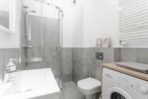 La salle de bains est pourvue d'une douche, de toilettes et d'un lave-linge. dans l'établissement Chill Apartments Airport Apartments, à Varsovie