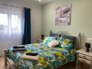 a bedroom with a bed with a colorful comforter at Casa Petit Paraiso in Lagoa +24 photos