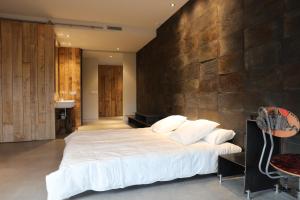 a bedroom with a large bed and a stone wall at Balneario de Calabor in Calabor