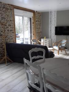 a living room with a couch and a table and chairs at Gite Le Ranch 6 pers in Tirepied