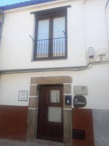 - Edificio con puerta y balcón en El Mullaero, en Aldeanueva del Camino
