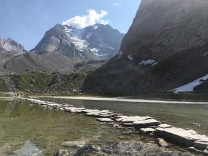 un fiume con rocce in mezzo a una montagna di Le Bouquetin 73 Appartement cosy type chalet avec piscine au pied des pistes et superbe vue panoramique a Pralognan-la-Vanoise