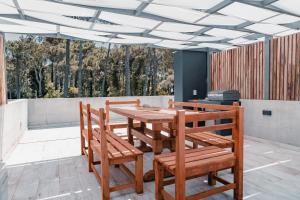 a wooden table and chairs on a patio at Arami Cariló in Carilo