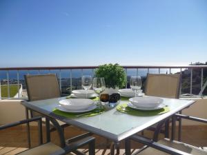 einen Tisch mit Tellern und Weingläsern auf dem Balkon in der Unterkunft Fine Duplex Apartment with Stunning Sea Views in Marbella