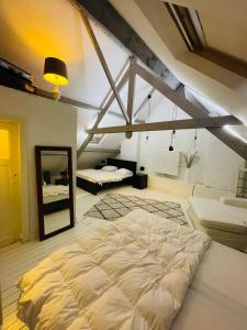 a large white bed in a room with a mirror at O-Sea House: herenwoning in Belle Epoque wijk te Oostende in Ostend