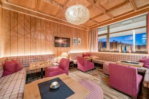 a restaurant with pink chairs and a table at Royal Hotel Hinterhuber in Brunico