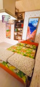 two beds in a room with paintings on the wall at Night in Upsidedown House in Petrovo