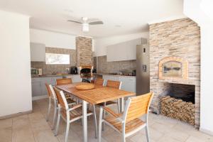 a kitchen and dining room with a wooden table and chairs at Casa Petit Paraiso in Lagoa