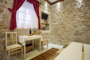 a stone walled room with a table and a window at Studios Balic Lux in Split