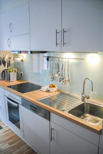 eine Küche mit weißen Schränken und einer Spüle in der Unterkunft Groot Huus in Norderney