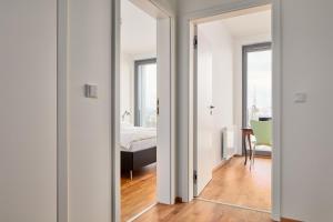 een slaapkamer met een bed en een kamer met een spiegel bij Designer Condo in Karlín by Prague Days in Praag