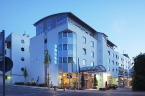 a large white building on a city street at Hotel Schwanen Stuttgart Airport/Messe in Filderstadt