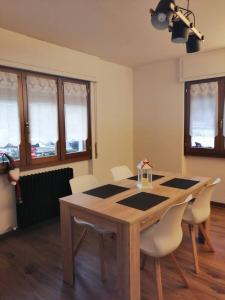 a dining room with a wooden table and chairs at Baggio House in Cadarese