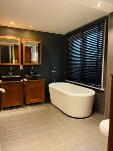 a large bathroom with a tub and two sinks at O-Sea House: herenwoning in Belle Epoque wijk te Oostende in Ostend