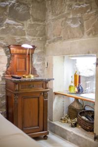 a kitchen with a wooden cabinet in a stone wall at Studios Balic Lux in Split