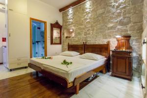 a bedroom with a bed and a stone wall at Studios Balic Lux in Split