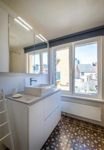 a bathroom with a sink and a large window at O-Sea House: herenwoning in Belle Epoque wijk te Oostende in Ostend