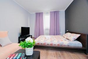 モスクワにあるKvartiraSvobodna - Apartment at Gerasima Kurinaのベッドルーム1室(ベッド1台、花のテーブル付)