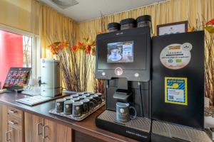 a coffee shop with a coffee machine on a counter at acom Hotel Berlin City Sued in Berlin