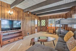 Quaint Cabin Retreat about 4 Mi to Arrowhead Lake في ليك أروهيد: غرفة معيشة مع أريكة وتلفزيون