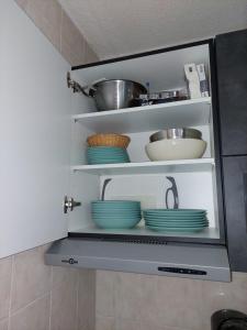 莱德萨阿尔卑斯Appart 3 étoiles 6 pers avec balcon luges et wifi - la meije 3 les 2 alpes 1800的厨房里带盘子和碗的架子