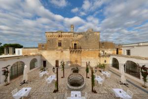 an old building with tables and chairs in front of it at Masseria Zanzara in Porto Cesareo