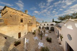 a courtyard in an old building with tables and chairs at Masseria Zanzara in Porto Cesareo