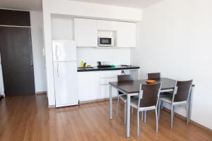 a kitchen with a table and chairs and a white refrigerator at BriDan in Rosario