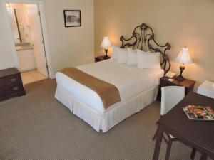 Habitación de hotel con 1 cama grande y 2 mesas en The Victorian Inn, en Telluride