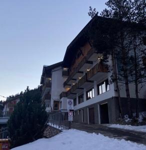 um grande edifício com neve em frente em Hotel Pizboè em Mazzin