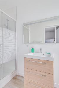 a white bathroom with a sink and a shower at Freedomus Marne-la-Vallée "Le 12" in Crecy la Chapelle