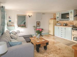 a living room with a couch and a table at Nightingale Cottage in Liskeard