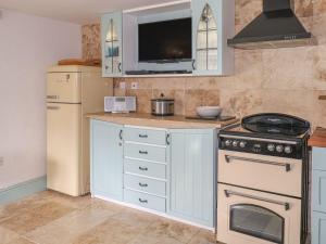 a kitchen with a stove and a refrigerator at Nightingale Cottage in Liskeard +11 photos
