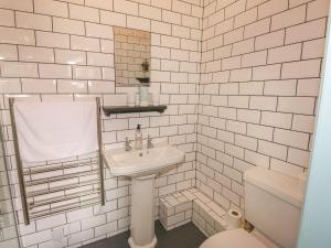 a white bathroom with a sink and a toilet at Nightingale Cottage in Liskeard