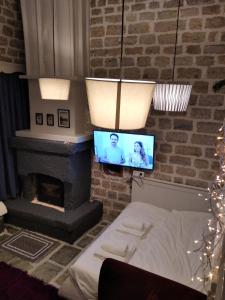 a living room with a fireplace and a television at Soul boutique hotel in Monodendri