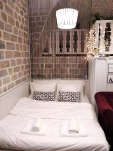 a white bed in a room with a brick wall at Soul boutique hotel in Monodendri