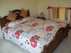 ein großes Bett mit einer Blumendecke darauf in der Unterkunft Anura Home Stay in Kalutara